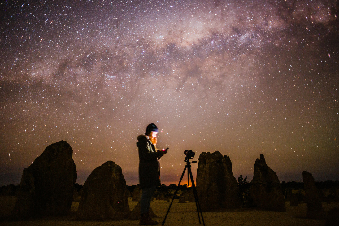 Woman with a Camera Standing Under the Starry Night